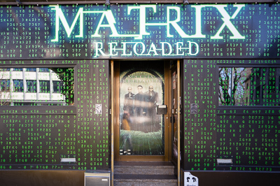 Façade Matrix, Stuttgart.
Ici, le cinéma déborde dans la rue : code vert, affiches et reflets mêlés. La matrice engloutit la façade, et la ville se reflète dedans comme un décor virtuel.