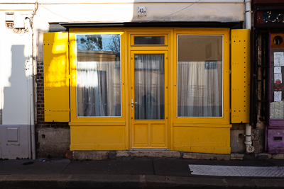 Rideaux blancs et façade jaune